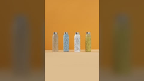 Four pastel tumblers lined up against a warm orange wall